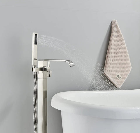 Freestanding Bathtub Faucet Floor Mount Tub Filler Brushed Nickel Brass Mixer Tap Waterfall Spout With Hand Shower next to a tub.