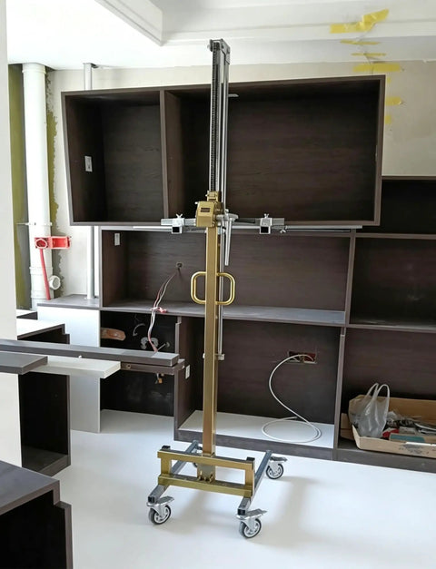 Portable Manual Material Lift With Winch And Forks For Easy Equipment Handling lifting equipment near cabinets in a workshop.