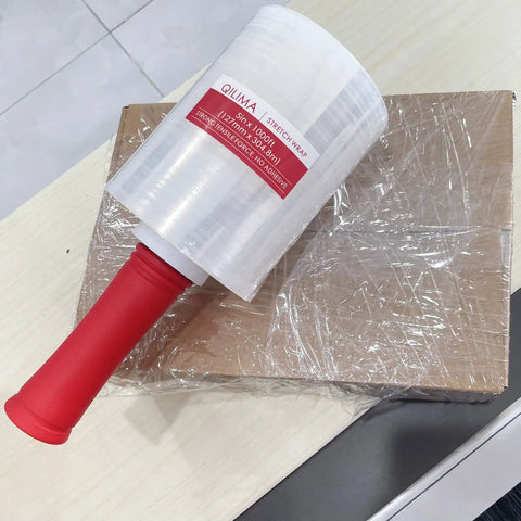 Pro Level Clear Industrial Stretch Wrap, Tough As Nails 80 Gauge Self Adhering Pallet Film For A Tight Lockdown Fit During Moving Or Long Term Storage, 5 Inch Rolls 1000 Feet, Four Pack With Snug Carry Handle on a packed box.