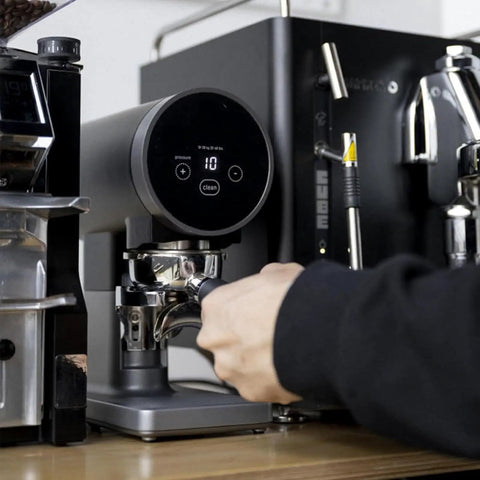 A user adjusts the 58mm Automatic Espresso Coffee Tamper With Adjustable Height and Custom Pressure Control on a coffee machine.