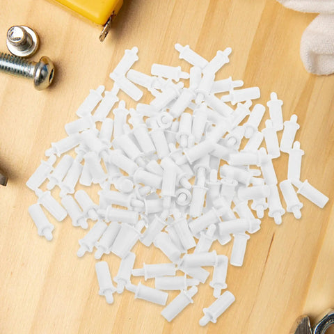 White Shutter Repair Pins, 120 Piece Movable Louver Fasteners scattered on wood surface, white plastic fasteners for shutters.