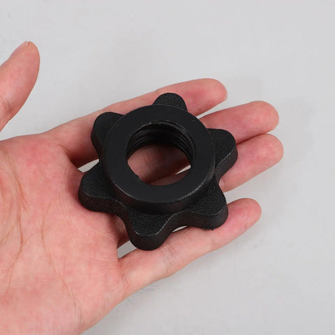 Hand holding a six-sided nut from Self Locking Barbell Collars Set Of 4 With Anti Skid Plastic Six Sided Nuts For Secure Weightlifting