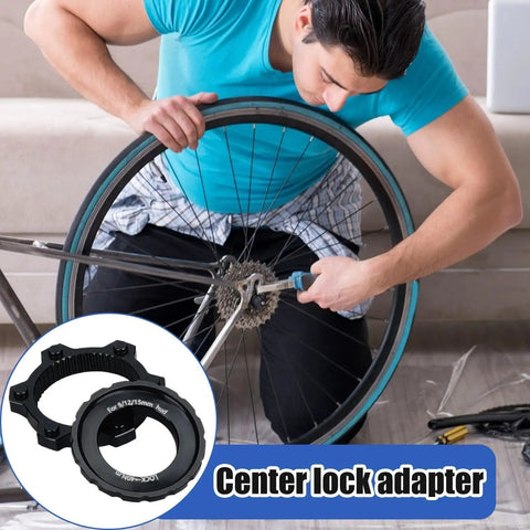 Person using Beefy Center Lock Bike Rotor Tool for upgrading ride, black aluminum adapters visible, cycling focus.