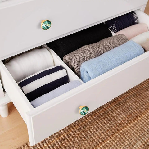 Four Piece Round Drawer Knobs And Cabinet Hardware Featuring Green And Gold Swirl Marbled Finish With Included Mounting Screws For Kitchen Cupboards And Dressers No Hassle Install Sweet Style Upgrade on a white dresser drawer with folded clothes.