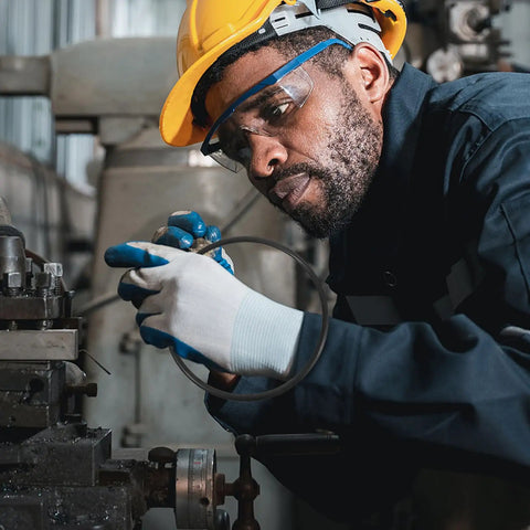 Man in safety gear working on machinery, inspecting a rubber belt for 2 Pack Industrial Rubber Belts For Continuous Sealing Machines And Auto Sealers Tough As Nails Wear Resistant Replacement Guide Transport Belt No Sweat Install.