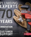 Plumbing experts 70 years innovation sign with gloves and wrench, highlighting Delta's commitment to service and support.