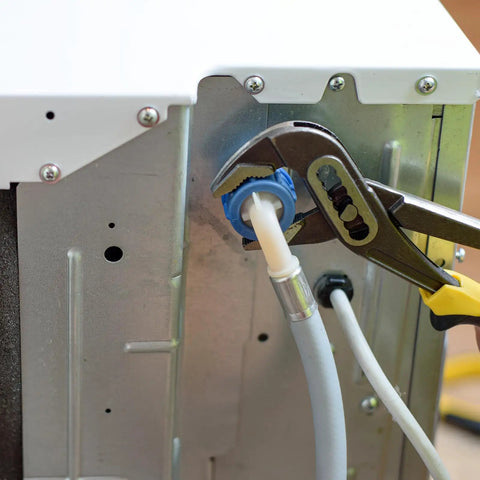 Pliers tightening a cable through a panel using Five Pack Rubber Grommets Black 1-1/4 Inch Outer Diameter for cable protection.