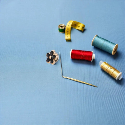 Twenty Piece Black Flower Snap Buttons Slick Metal Clip On Fasteners For Apparel Repairs placed with thread spools and a measuring tape.