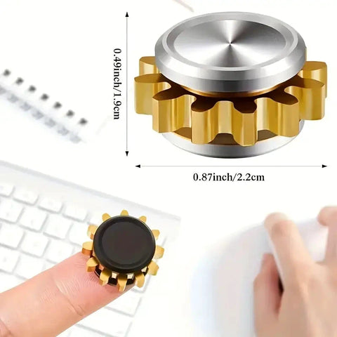 Mini Metal Gear Gyroscope Toy Fidget Spinner Portable Black with brass gear and aluminum cap, size 0.87 inches, on finger near keyboard.