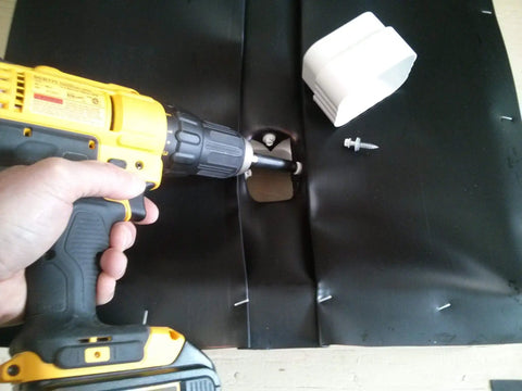 Person installing Dry Under Deck Drainage System Roll For 50 Feet, Fits 12 Inch Joists with drill and screw downspout.