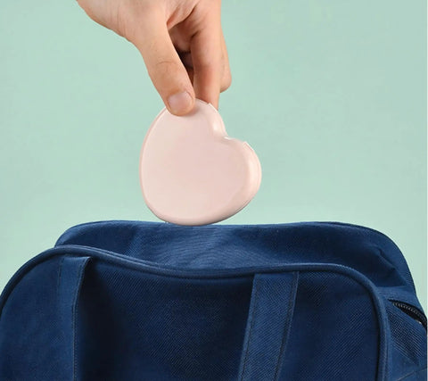 Hand holding a pink heart-shaped case for the Compact Travel Sewing Kit Two Pack Featuring Adorable Heart Shaped Cases Pink And Blue.