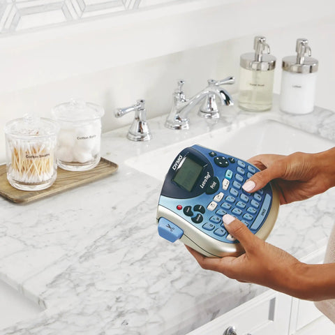 Person using Portable Handheld Label Maker With QWERTY Keyboard And 2 Line Printing near a bathroom sink