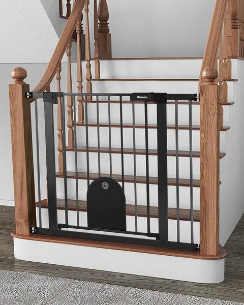 Wide Auto Close Baby Gate With Cat Door For Easy Walk Through Adjustable 29.7 To 40.6 Inches Pressure Mounted Or Hardware Mounted Durable Pet Gate For Stairs And Doorways Black installed at the bottom of a wooden staircase