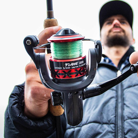 Angler holding Flame Spinning Reels Ultra Lightweight And Smooth Drag Up To 19.8 Pounds Graphite Body Black And Red 2000 Series