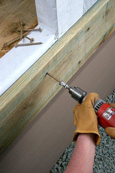 Using a drill with Exterior Grade Timber Screws 0.220 Inch By 4 Inch Double Barrier Coated on outdoor wood project.