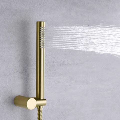 Top Notch Brushed Gold Shower Faucet System with handheld spray head releasing water stream against a gray wall.