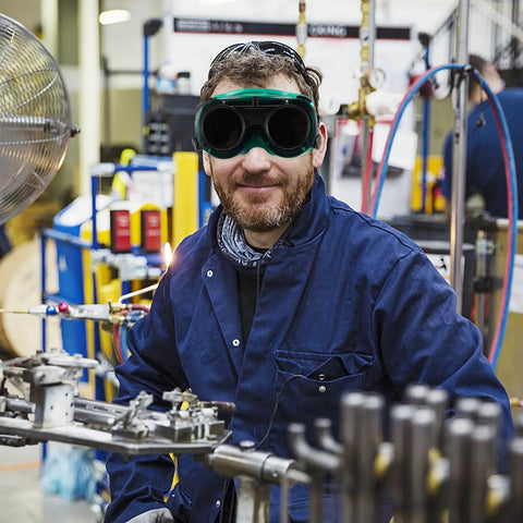 Kick Ass Flip Up Welding Goggles Heavy Duty Safety Glasses Rugged 2 Pack Welder Shades worn by a man in an industrial setting.