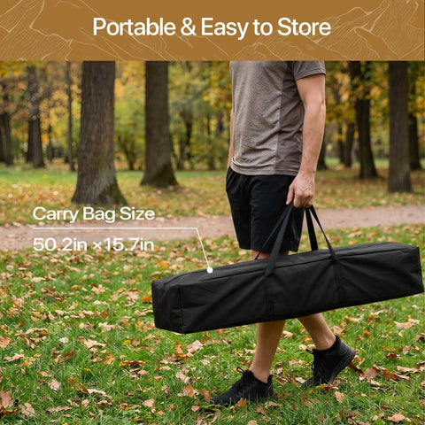 Person carrying Portable Hammock With Folding Stand Heavy Duty Steel Frame For Indoor And Outdoor Use Three Height Settings 550 Lbs Weight Capacity Includes Carrying Bag Off White Rust Resistant Easy Setup For Backyard Lounging in a black carry bag in a forested area.