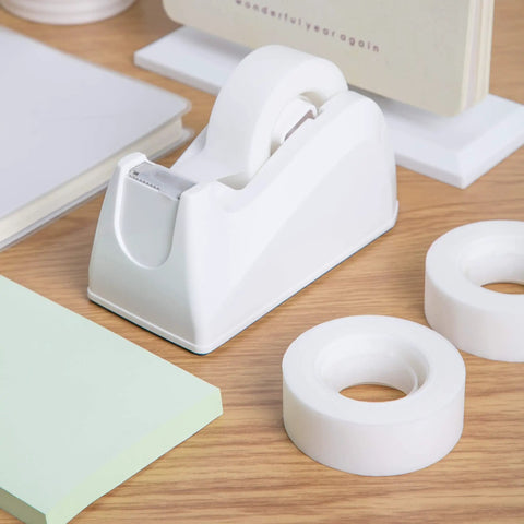 Solid Grip Invisible Tape With Smooth Matte Dispenser And Sixteen Heavy Duty Refill Rolls Zero Shine Finish Ideal For Paper Arts And Daily Tasks A Flat Out Winner in a workspace with a white tape dispenser and rolls.