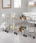 Metal Storage Rack On Wheels Floor Standing Movable Shelving Unit in bathroom setting with toiletries and plants