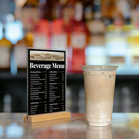 5x7 Inch Acrylic Sign Holder With Beech Wood Base For Vertical Or Slant Back Desk Display Perfect For Store Or Office Clear High Gloss Panel With Slick Wood Frame Durable Modern And Budget Friendly displaying beverage menu next to iced coffee