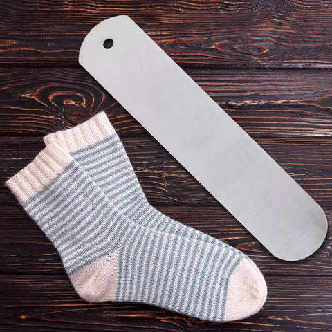 Aluminum Sock Jig Set For Sublimation 17.71 Inch 4 Pack next to striped socks on a wooden background