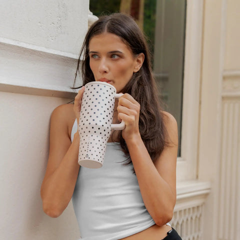 40oz Polka Dot Insulated Tumbler Featuring A Spill Proof Flip Straw And Comfort Grip Handle, held by a woman, perfect for hydration.