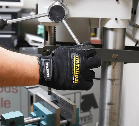 Close-up of General Utility Spandex Work Gloves Black Large Pair gripping machinery in workshop, showing padded palm and knuckle protection.