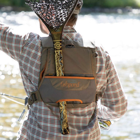 Back view of Cross Current Chest Pack For Fly Fishing Gear, Durable 210D Nylon Cyclepond Fabric, worn by a person by the river