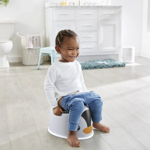 Nifty Toddler Potty Training Seat With A Cool Penguin Face And Sturdy Grasp Handles For Little Ones Featuring An Easy Clean Removable Bowl Built In Splash Guard And Travel Handle For Zero Hassle Bathroom Wins used by smiling child in bathroom.
