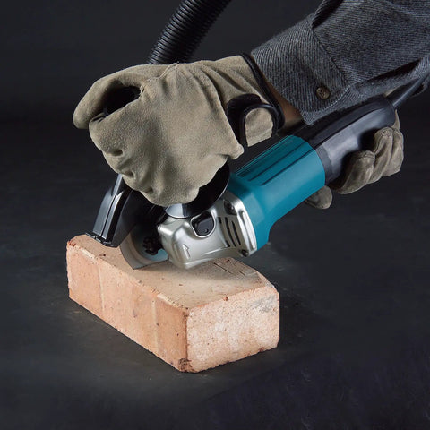 Powerful 4-1/2 Inch Angle Grinder With Kick Butt Strength cutting through a brick with dust control.
