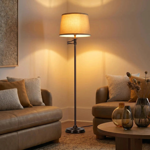 Caden LED Floor Lamp With Swing Arm Tall Bronze Standing Light illuminating a cozy living room with modern decor.