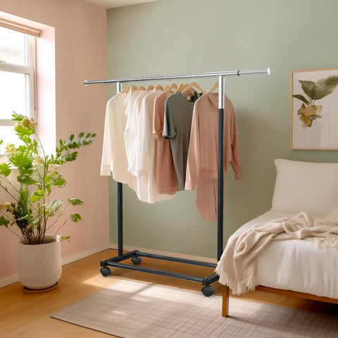 Heavy Duty Steel Clothing Rack With Extensible Top Rod And Chrome Accents In Slick Black Paint Built Solid For Dorm Life And Cramped Closets Easy Setup Rack To Hang All Your Threads Stress Free with clothes displayed in a bedroom.