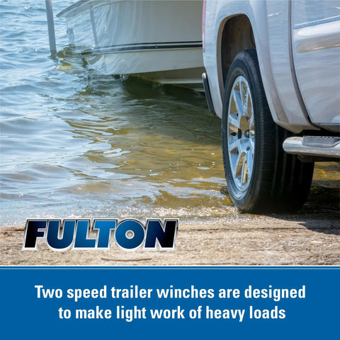 Two Speed Trailer Winch With 2,600 Lb Capacity, loading boat onto trailer by water, tire and winch visible, silver finish.