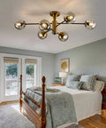 6-Light Sputnik Gold Ceiling Light Fixture With Glass Globe in bedroom, exhibiting mid-century chandelier style