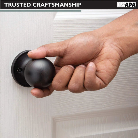 Hand gripping Black Matte Ball Style Passage Door Knob on white interior door, non locking, for closets and pantries.