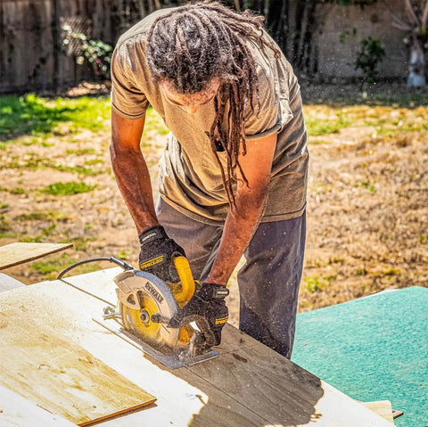 Man using saw wearing General Utility Spandex Work Gloves Black Large Pair With Padded Palm Rubberized Knuckle Protection