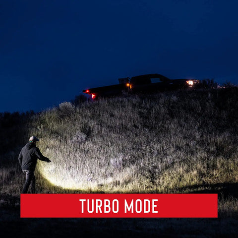 XP18R 3650 Lumen USB C Rechargeable Dual Power LED Flashlight in Turbo Mode lighting up a dark hillside with a truck visible