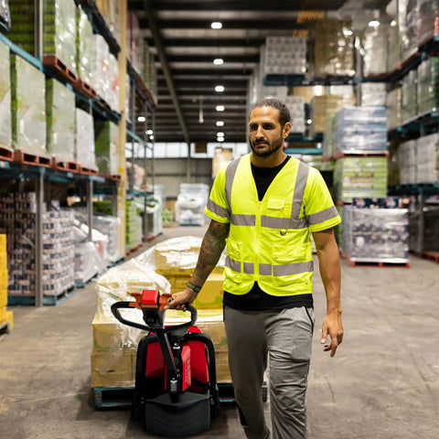 Powerhouse Full Electric Pallet Jack Bundle With Amps Boosting 4800 Lbs Capacity And 48 Inch Forks Plus Huge 48 Volt Lithium Battery in use by worker.