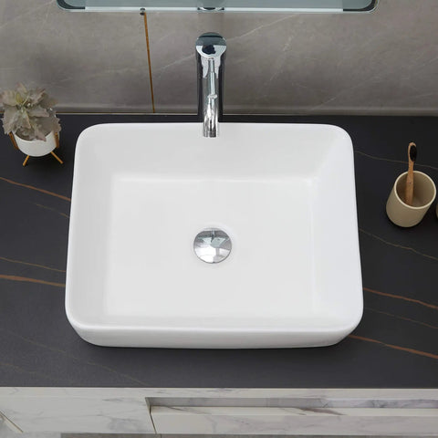 Top view of Rectangle Vessel Sink With Pop Up Drain Included For Above Counter Bathroom White Porcelain Ceramic Vanity Basin 14.6 X 18.9 X 5.2 Inches Without Faucet Hole on a dark countertop.