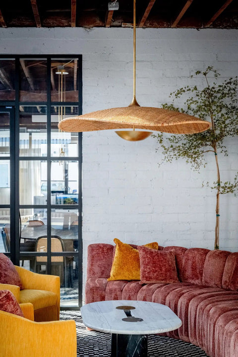 Totally Main Character Energy One Light Pendant Ceiling Light Fifty Two Inches Wide Vintage Gold Leaf Metal Dome Shade Hanging Lamp above a cozy living room.