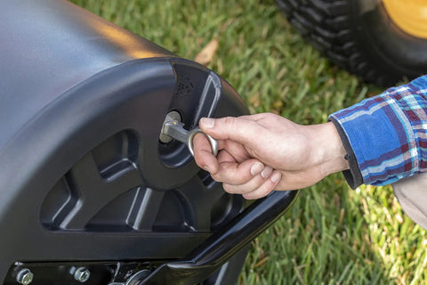User adjusting drain plug on Tow Behind 18 Inch By 36 Inch Poly Lawn Roller Water Filled To 400 Lb Weight Durable Poly Drum