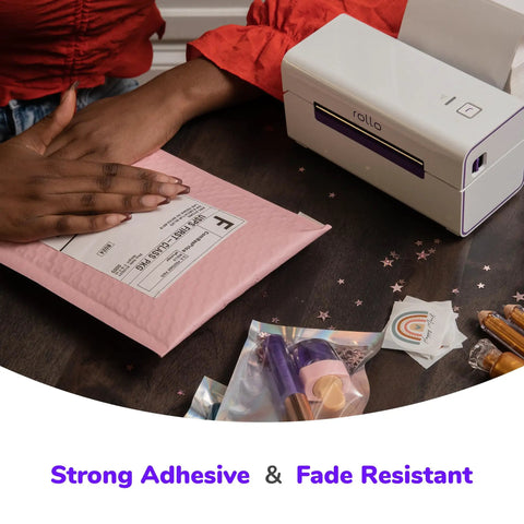 Person applying Direct Thermal Shipping Labels 4x6 Roll, 500 Perforated Labels With Strong Adhesive For Ecommerce on pink mailer