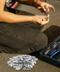 Person using tools next to heavy duty steel strapping clip with iron buckle for industrial packaging and pallet shipping, 1kg plastic seals