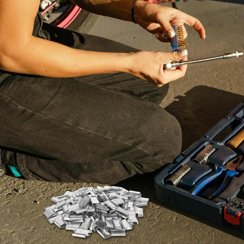 Person using tools next to heavy duty steel strapping clip with iron buckle for industrial packaging and pallet shipping, 1kg plastic seals
