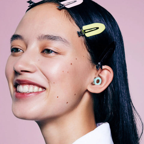 Model wearing Reusable Silicone Ear Plugs For Snagging Shut Eye And Stress Relieving Road Trips Delivering Real 24Db Noise Reduction.