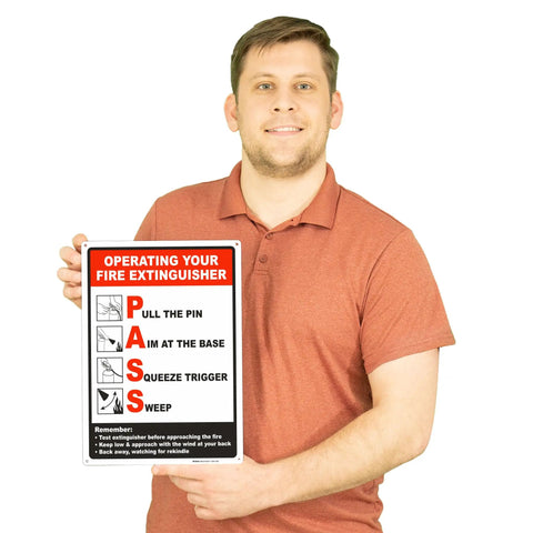 Person holding a 10 By 14 Inch Fire Extinguisher Sign Made From Durable Polyethylene Plastic With Bold Text And Symbol Clear Operating Instructions For Easy Fire Safety And Quick Wall Mount Install.