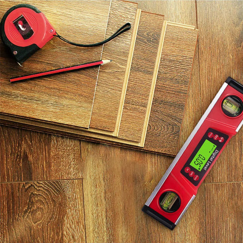 10 Inch Digital Level And Protractor With IP54 Inclinometer on wooden flooring next to tape measure and pencil