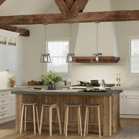 Coastal 1-Light Mini Pendant in Antique Bronze for Rustic Farmhouse Vibe hanging over kitchen island with stools