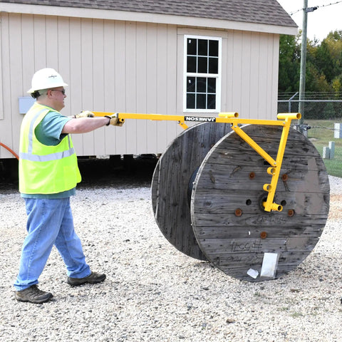 Worker using Beefed-Up Heavy Duty Portable Reel Buck With Adjustable Steel Cable Reel Stand, 1000 Lb Capacity on large cable reel